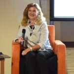 Ewa Małkowska-Bieniek siedzi na fotelu w bibliotece.
