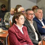 Grupa trzech radnych UM Sokołów Podlaski z przewodniczący Rady Miasta Daniele Krakowski oraz sekretarz UM Urszula Rozbicka siedzą przy stoliku w bibliotece. Z nimi inni uczestnicy spotkania.