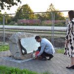 Pracownicy Muzeum w Treblince Ilona Flażyńska i Krzysztof Flażyński stawiają znicz przy pomniku.