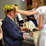 Jedna z trzech ubranych na biało dziewczyn zakłada wianek wianek wice staroście Zbigniewowi Czerkasowi.
