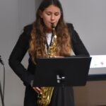Uczennica szkoły muzycznej podczas gry na instrumencie dentym.