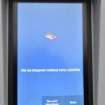 Ekran książkomatu z napisem "Aby się zalogować zeskanuj kartę czytelnika"