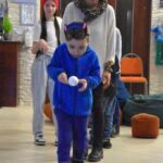 Dziecko bierze udział w zabawie zręcznościowej podczas balu karnawałowego.