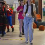 Dzieci biorą udział w zabawie zręcznościowej podczas balu karnawałowego w bibliotece.