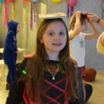 Dziecko w stroju karnawałowym podczas zabawy w bibliotece.