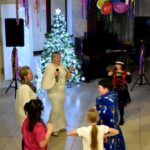 Dzieci tańczą podczas balu karnawałowego w bibliotece.