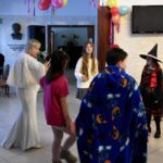 Dzieci bawią się podczas balu karnawałowego w bibliotece.