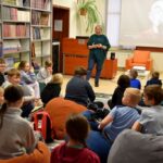 Dzieci uczestniczą w seansie filmowym i zajęciach w bibliotece.
