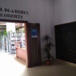 Na fotografii fragment ściany pomalowany czarną farbą tablicowo-magnetyczną. Znajduję się na pierwszym piętrze biblioteki tuż przy wyjściu z windy a przed wejście do Działu dla dzieci.