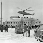 Zdjęcie przedstawia budynek Sokołowskiego Ośrodka Kultura, wykonane zimą. Nad budynkiem wznosi się helikopter. W kilku niedużych grupach stoją ludzie przyglądający się lecącej maszynie.