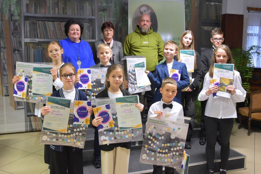 Zwycięzcy konkursu recytatorskiego im. K.I. Gałczyńskiego oraz komisja pozujący do zdjęcia w bibliotece