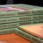 Kilka książek autora z zieloną okładką ułożona jedna na drugiej. Widać grzbiety książek z tytułem - Bartłomiej Dejnega - Prawieści. Mity Słowian.