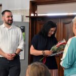 Dyrektor biblioteki Małgorzata Iwańska-Kania trzyma kwiaty, które otrzymała od uczestniczki kursu. Obok stoi uśmiechnięty mężczyzna - prowadzący kursy komputerowe.