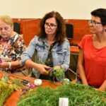 Trzy kobiety podczas warsztatów w bibliotece wykonują kadzidła słowiańskie z ziół.