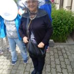 Uśmiechnięta seniorka w kapeluszu pszczelarskim podczas warsztatów pszczelarskich.