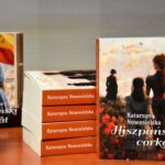 Wystawka książek autorki. Książki ułożone są jedna na drugiej, grzbietami w kierunku obiektywu. Dwie książki ustawione są pionowo.