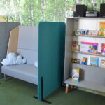 Regał z książkami i muzyką oraz wieżą audio w pokoju wyciszeń.