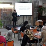 Dyrektor biblioteki Małgorzata Iwańska-Kania wita zebraną publiczność na spotkaniu.