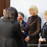 Małgorzata Iwańska-Kania wręcza byłym pracownikom biblioteki czerwone róże.
