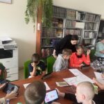 Grupa dzieci podczsa warsztatów w bibliotece.